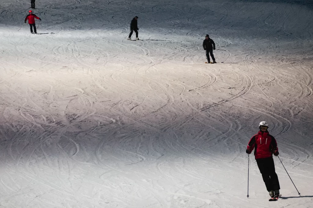 Лыжники спускаются по трассе для горных лыж