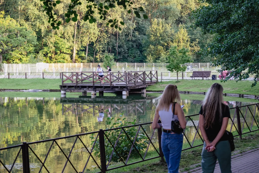 Люди прогуливаются около пруда Ботанического сада, Минск, Беларусь
