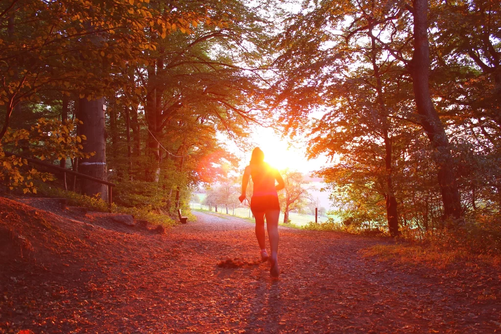 Девушка бежит на закате по осеннему парку