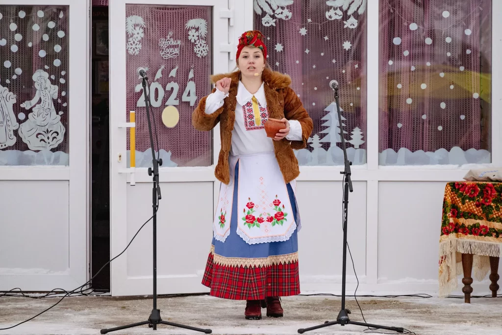Женщина в народном костюме выступает перед гостями обряда "Калядныя цары" в деревне Семежево, Беларусь