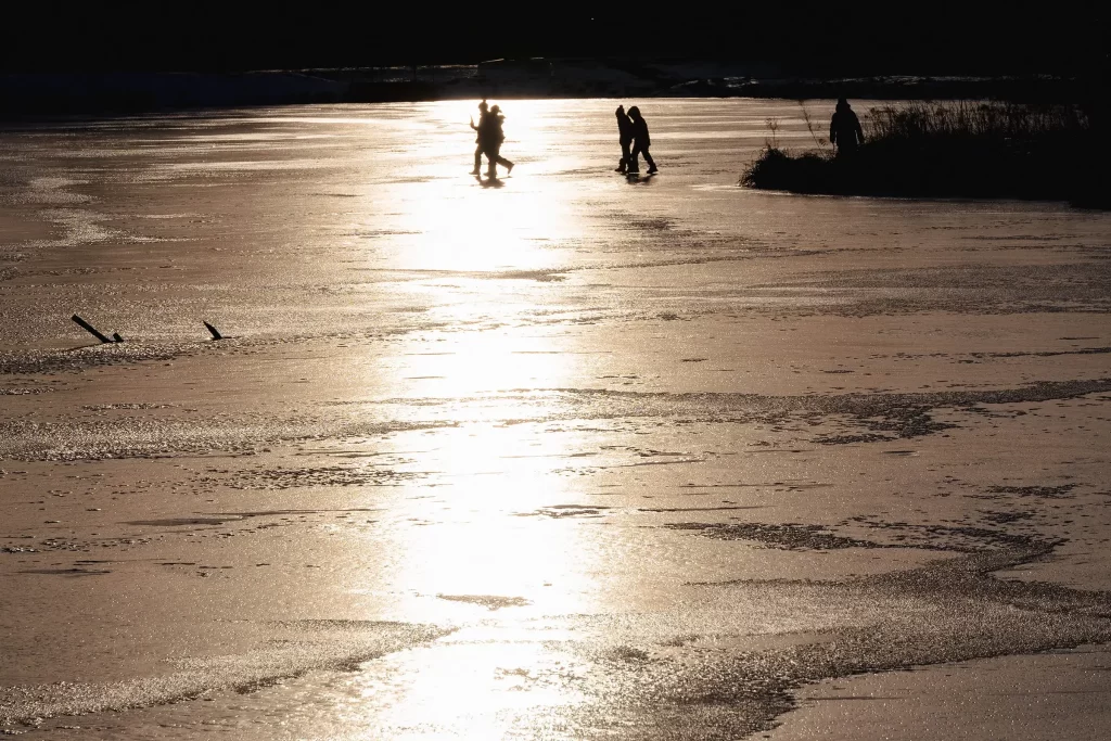 Дети на льду озера в лучах заходящего солнца, Прилуки, Беларусь